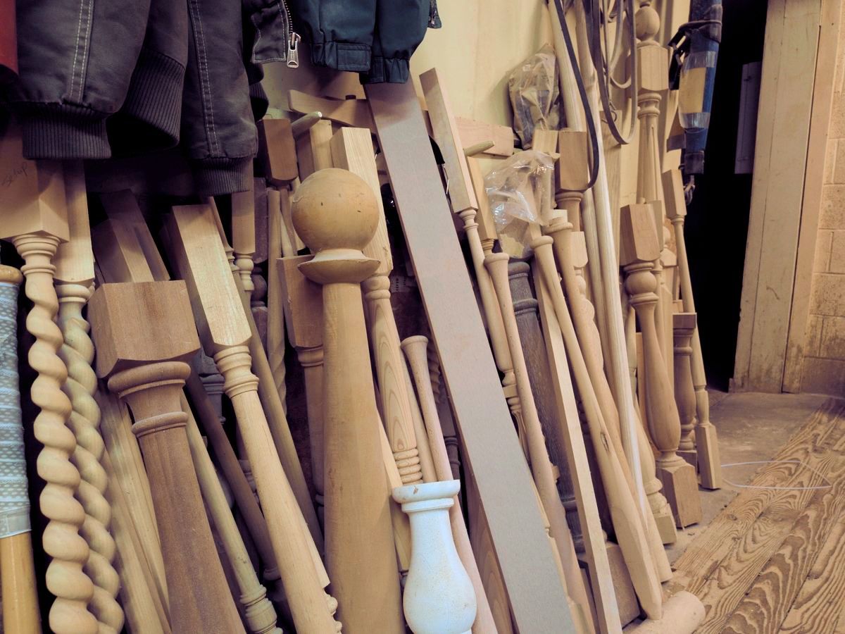 A collection of turned spindles, each in a different profile, standing against a wall.